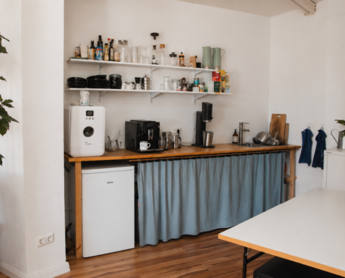 Küchenzeile im Billroth Büro – voll ausgestattet mit Geschirrspüler, Kaffeevollautomat, Mikrowelle und Herdplatte.